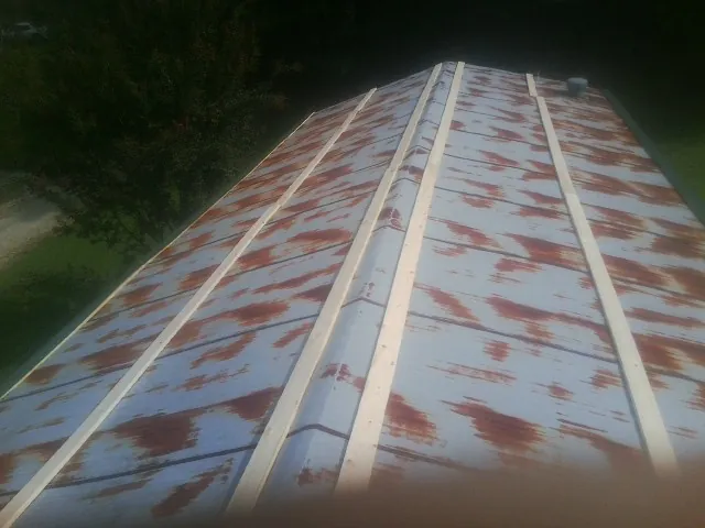 Rusted metal roof panels with new wood purlins before replacement — Storm Damage Roof Repair in Fleming Island by Roofing Brothers
