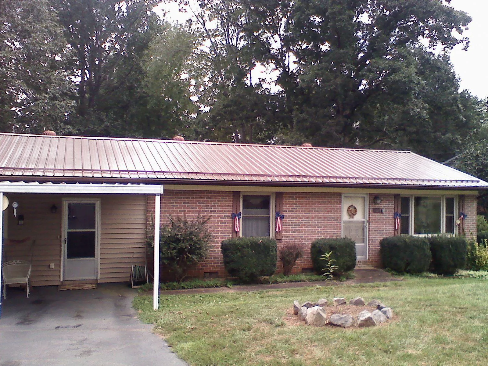 Bronze metal roof and carport on a brick ranch home — Roof Repair work by our crew in Fleming Island